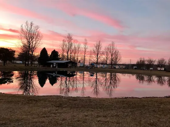 A pink sunset reflected in the campground pond